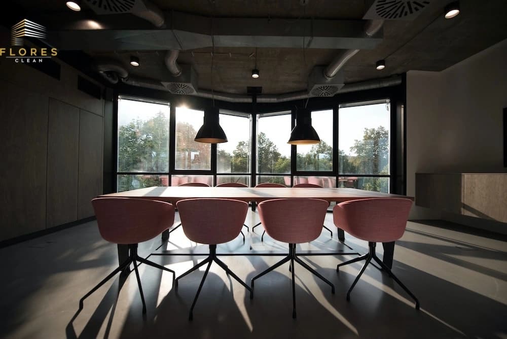 A modern commercial boardroom with floor-to-ceiling windows and a polished concrete floor, maintained to a deep-clean standard