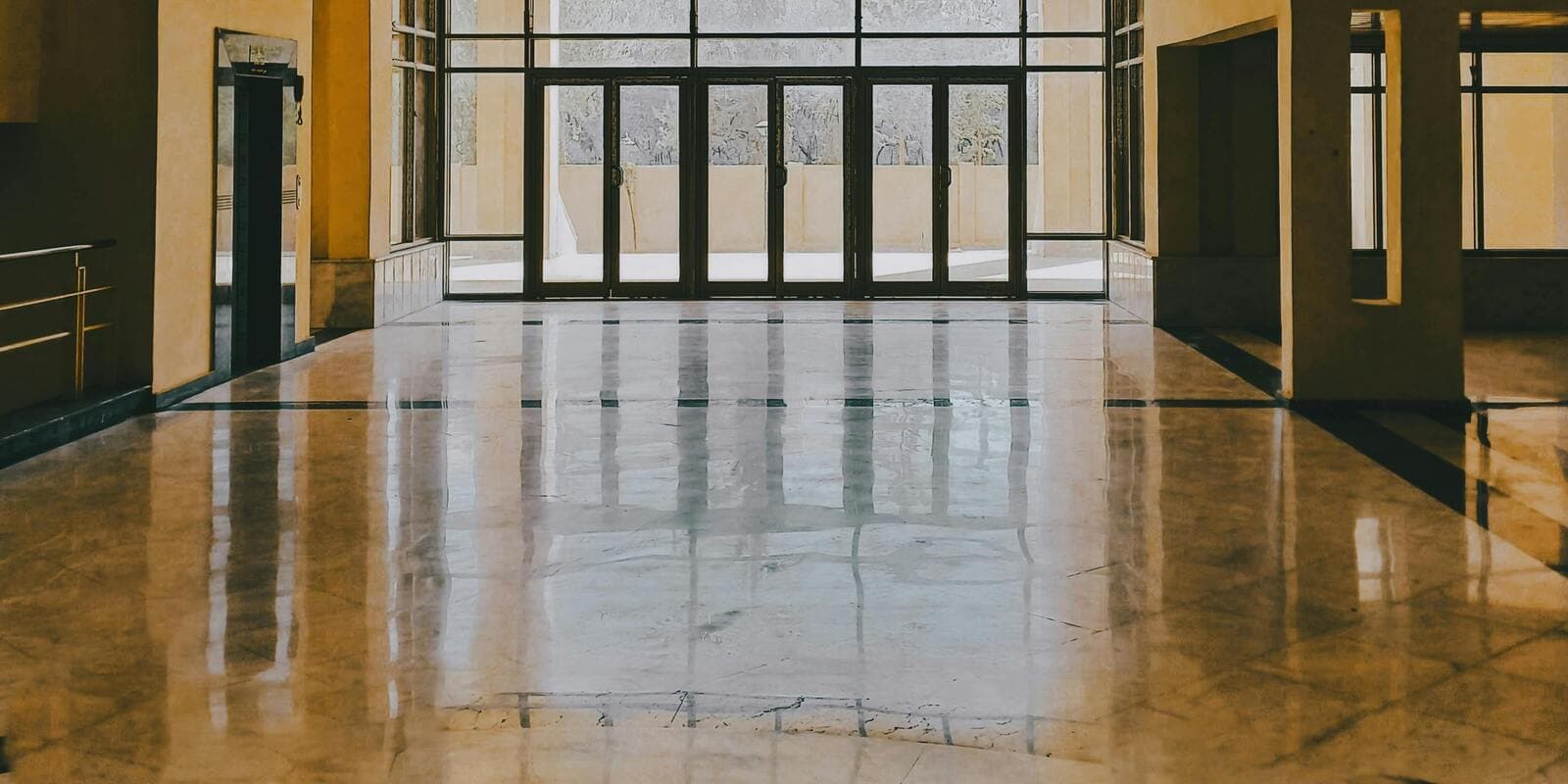 Freshly buffed high-gloss stone floor in an institutional lobby