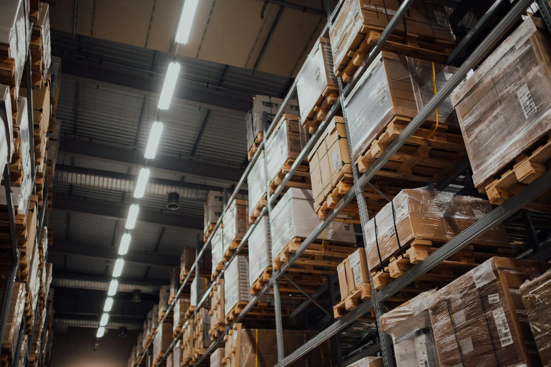 A warehouse with tall pallet racking and a polished concrete floor under industrial lighting