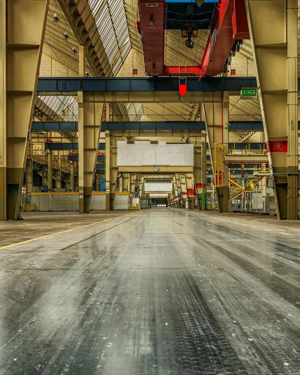 The interior of a large industrial warehouse with an overhead crane and a polished concrete floor