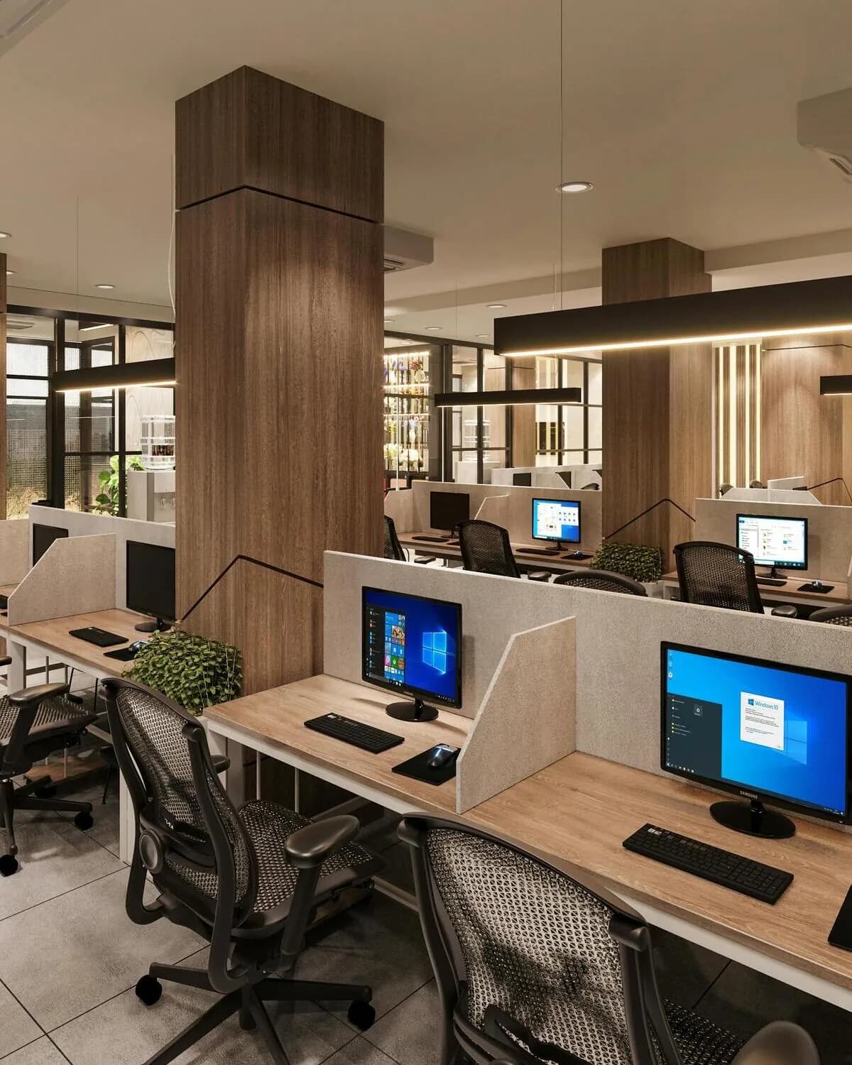 A modern open-plan office with rows of desks, monitors, and ergonomic chairs